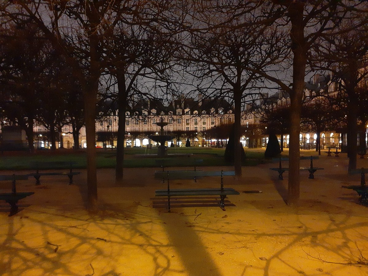 Les arcades de la place des Vosges éclairées la nuit